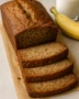 "Moist homemade banana bread loaf sliced on a cutting board"